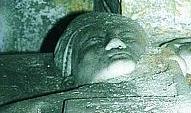 Il primo piano di una statua funeraria conservata nella chiesa e le campane originali dell’800 che si mantengono per miracolo a travi di legno divorate dall’umidità